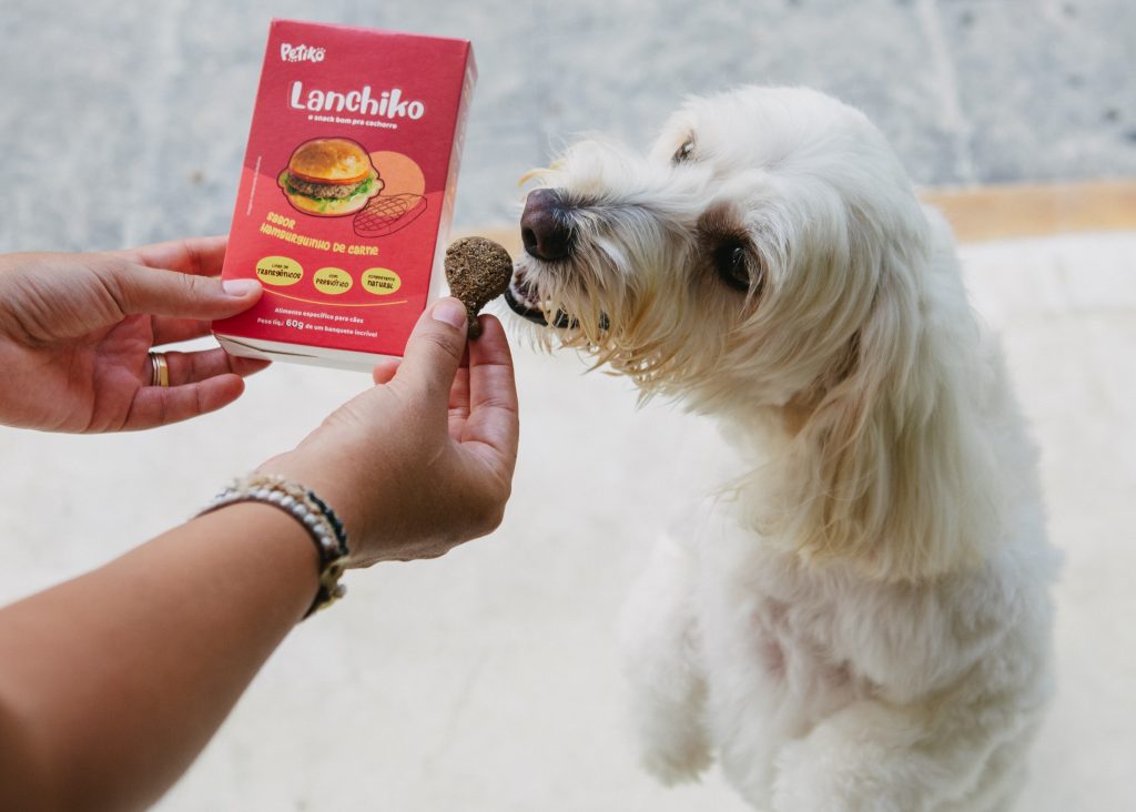 Tutora oferecendo Lanchiko – Petisco sabor hamburguinho de carne enviado no BOX.Petiko para seu cachorro